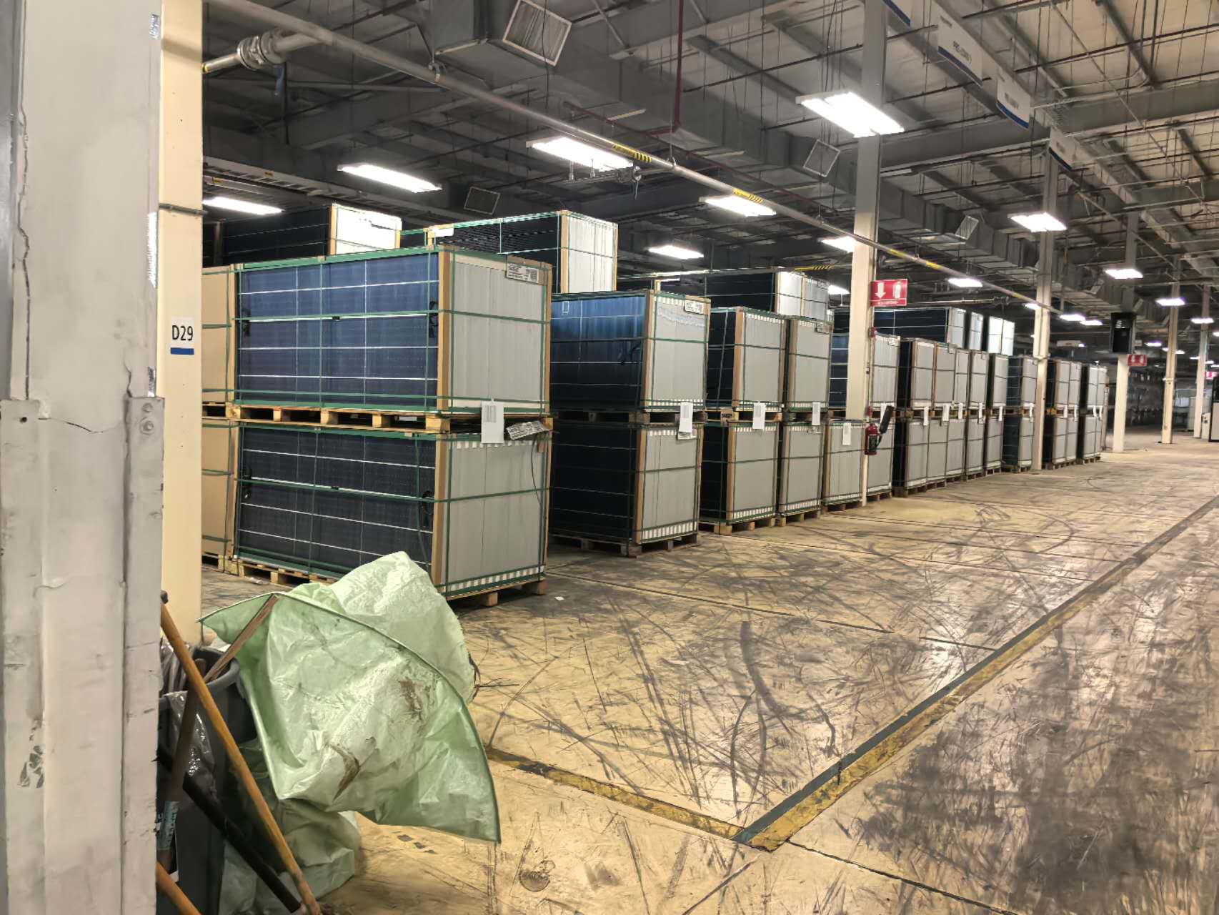 Rows of packaged solar panels stored inside the manufacturing facility